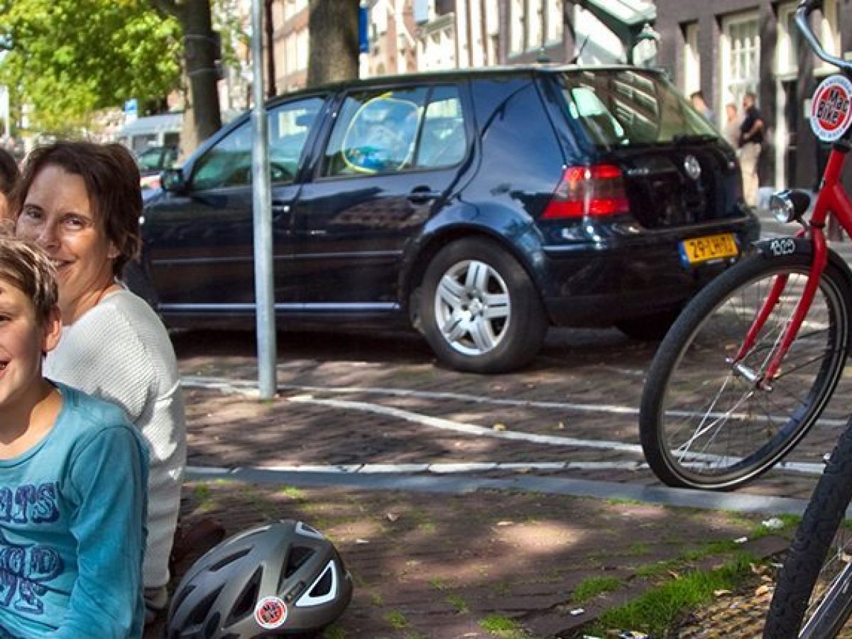 a little girl riding on the back of a bicycle