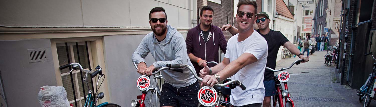 boys-macbike-amsterdam-city-bike-rental_1500x430 a man standing next to a bicycle