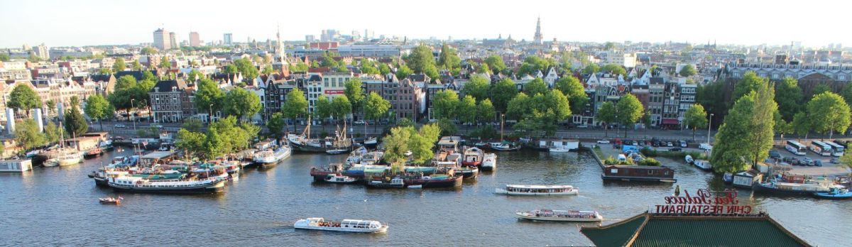 Amsterdam skyline a small boat in a body of water with a city in the background